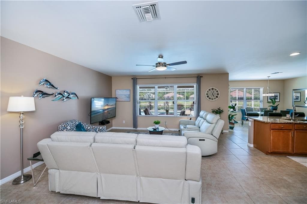 Living room featuring plenty of natural light, a ceiling fan, light tile patterned flooring, and recessed lighting