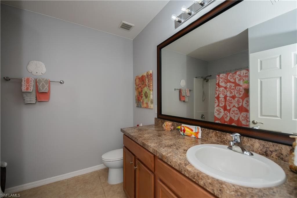 Bathroom with tile patterned flooring, vanity, a shower with shower curtain, and toilet