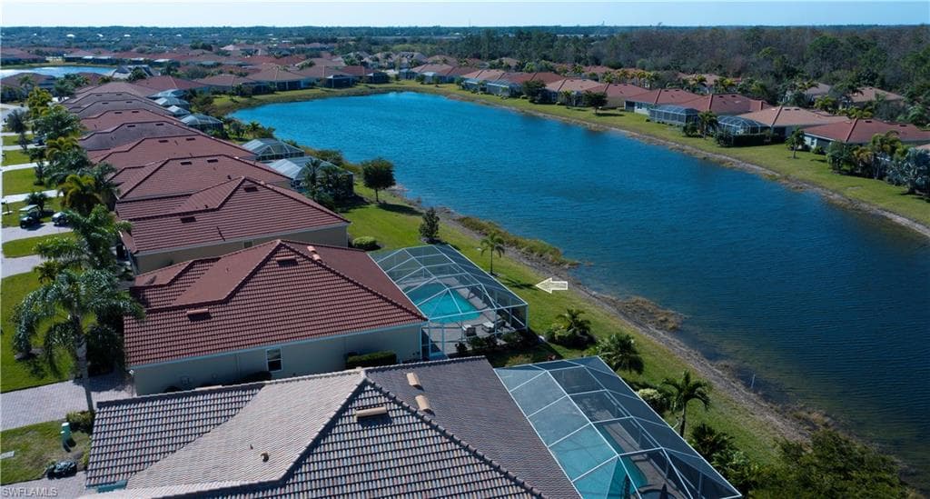 Birds eye view of property with a water view