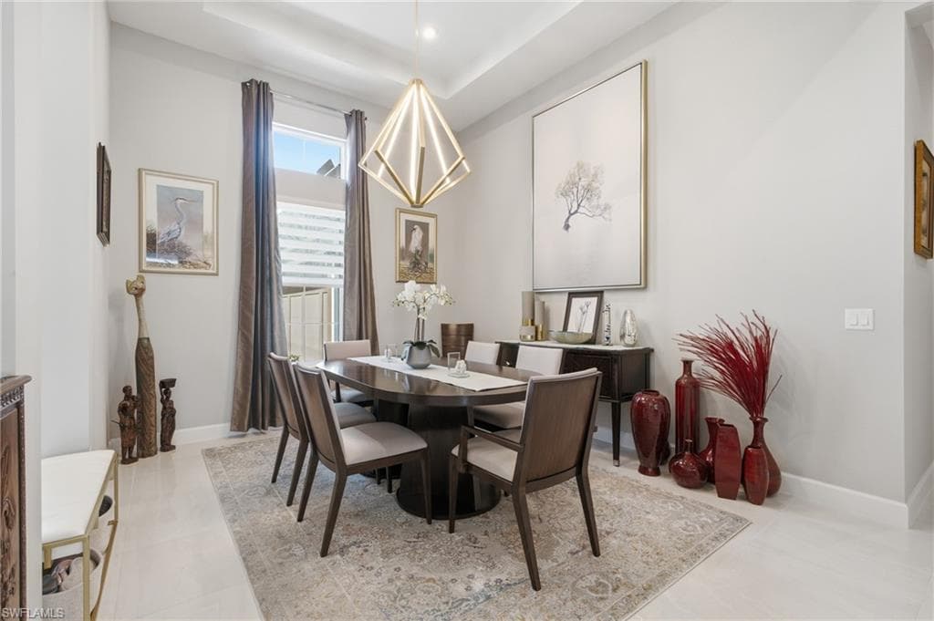 Recessed ceiling with a contemporary chandelier, large window with privacy blinds, light wood-finish flooring, and crown molding