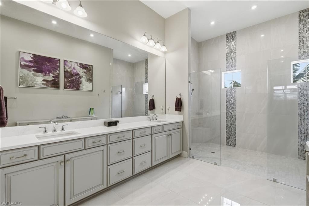 Bathroom featuring a light gray dual vanity with undermount sinks and chrome fixtures