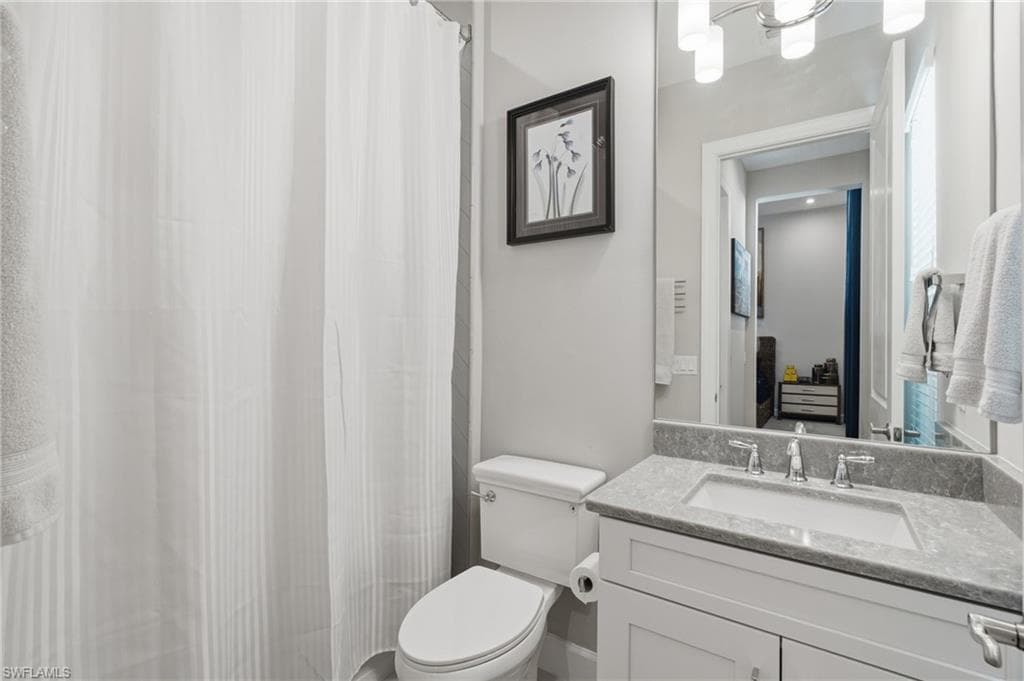 Bathroom vanity with a rectangular sink, stone countertop, and chrome faucet