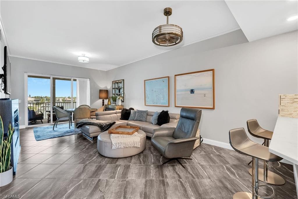 Spacious living area featuring contemporary tile flooring, crown molding, and recessed lighting