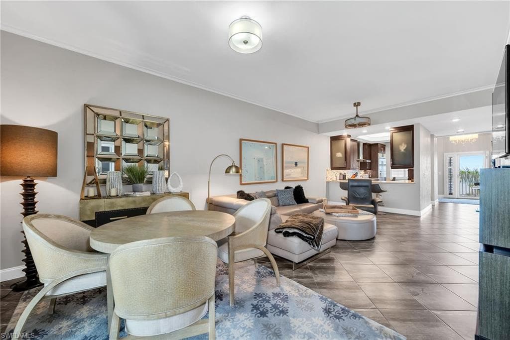 Open-concept living area with tile flooring and crown molding