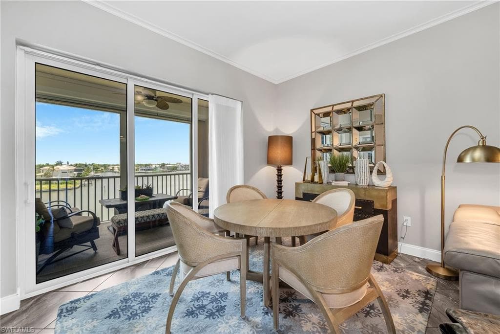 Sliding glass doors open to a spacious balcony with water and distant landscape views