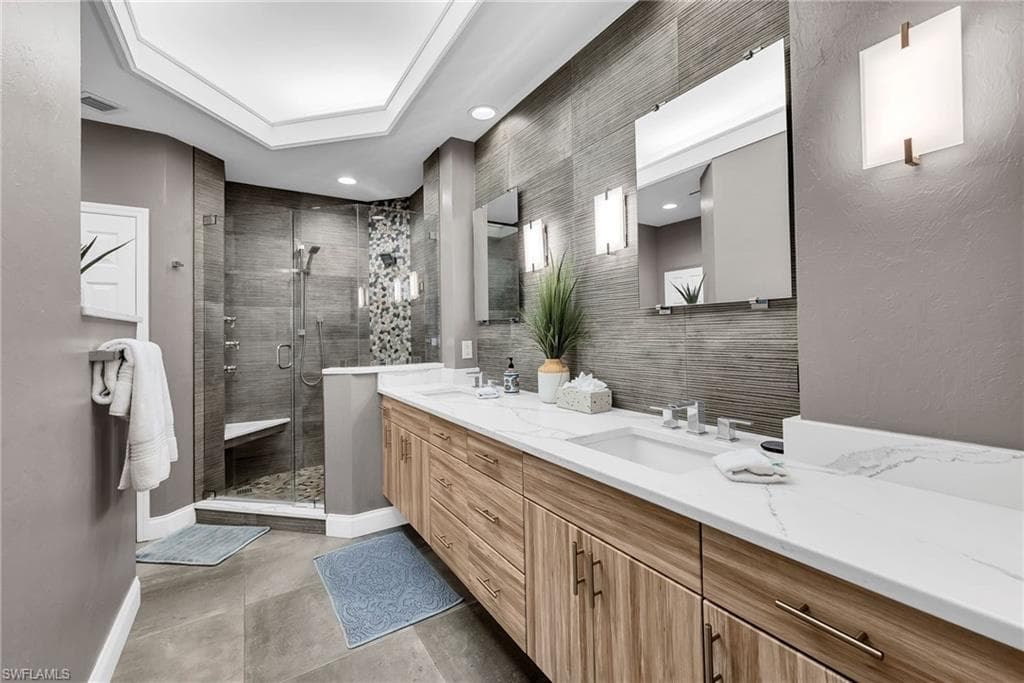 Bathroom featuring a dual vanity with wood-finish cabinetry and white countertops