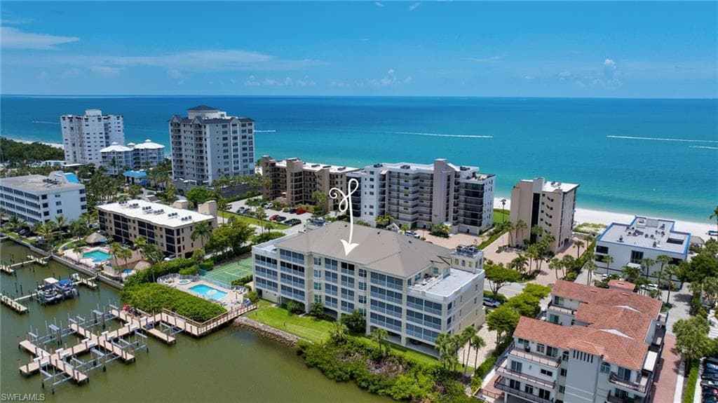 Waterfront condominium property featuring multiple balconies, a swimming pool, and dedicated boat docks