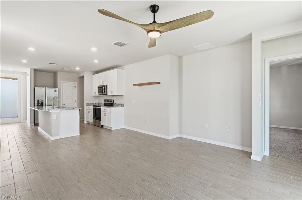 Open-concept living area featuring wood-finish flooring and a contemporary ceiling fan