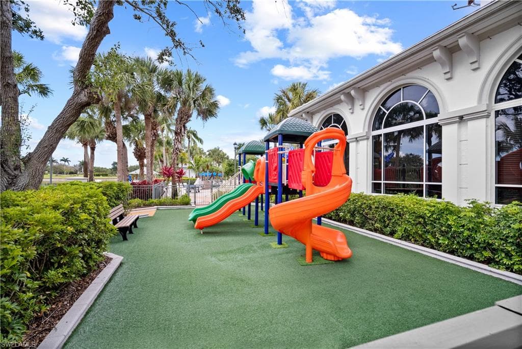 Community playground featuring a soft-surface base, multiple slides, and integrated play structures