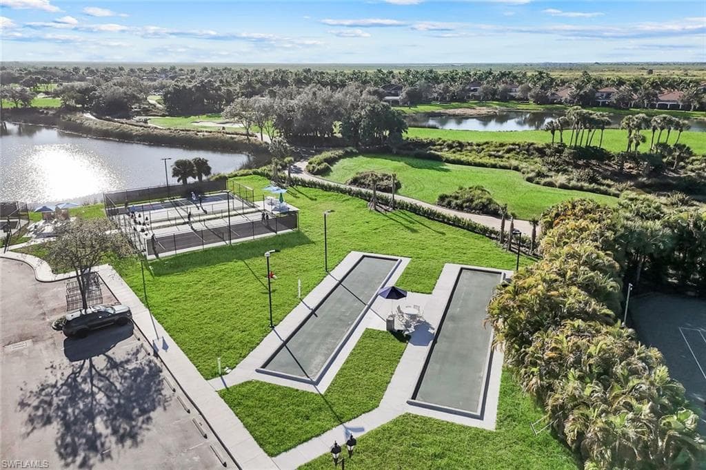 Two bocce ball courts set on manicured green space, complemented by two paddleball courts with black fencing