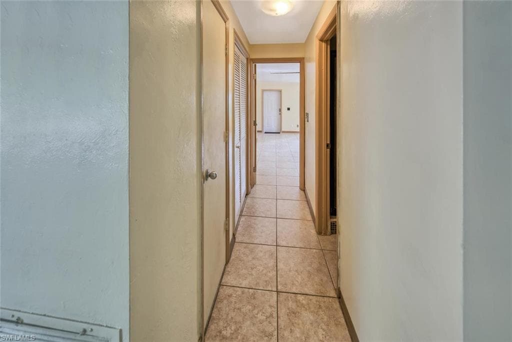 Hall with light tile patterned flooring
