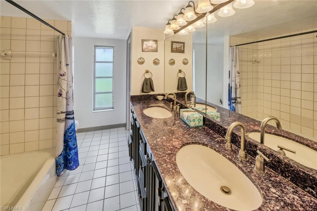 Bathroom with tile patterned flooring, vanity, and shower / bath combo