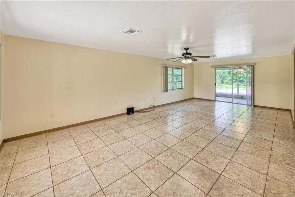 Unfurnished room featuring light tile patterned flooring and ceiling fan