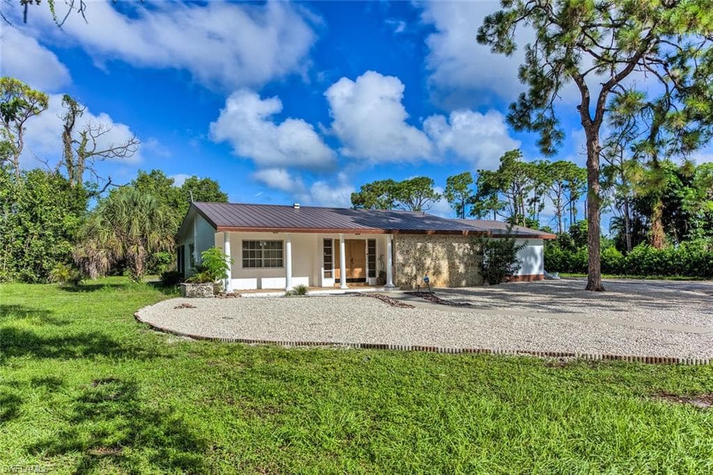 Rear view of property with a lawn