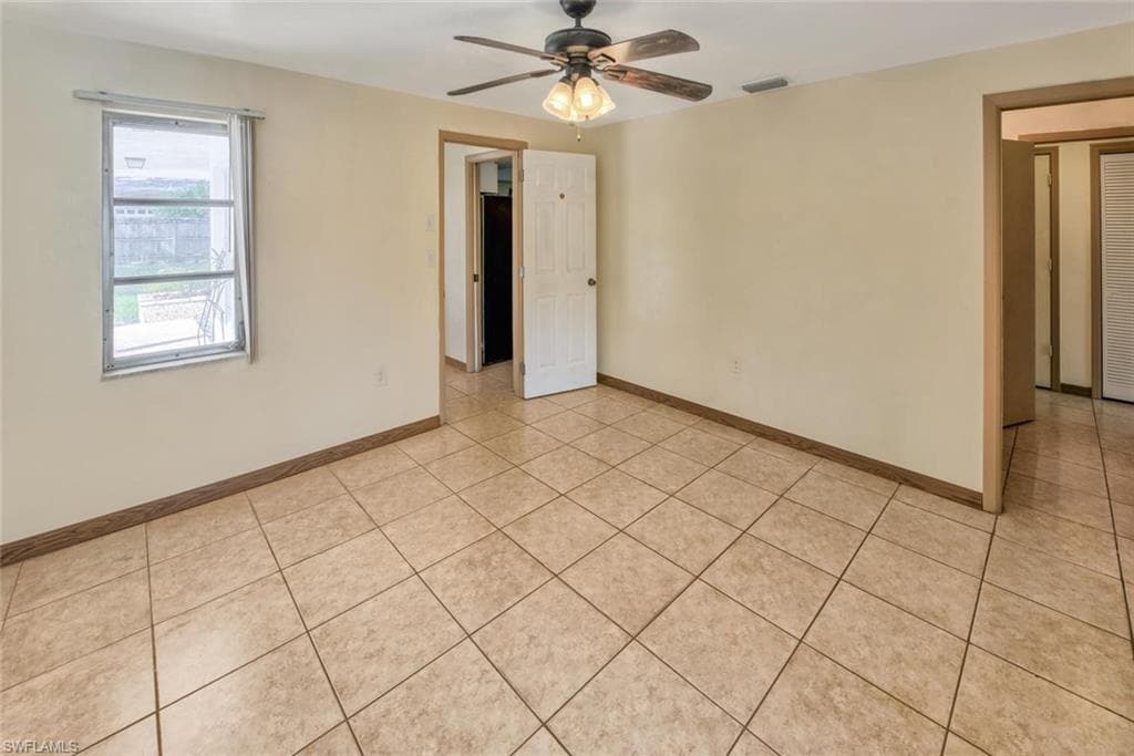 Tiled spare room with ceiling fan