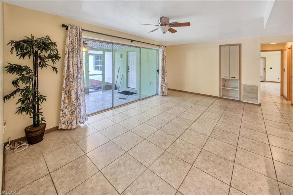 Unfurnished room with light tile patterned flooring and ceiling fan