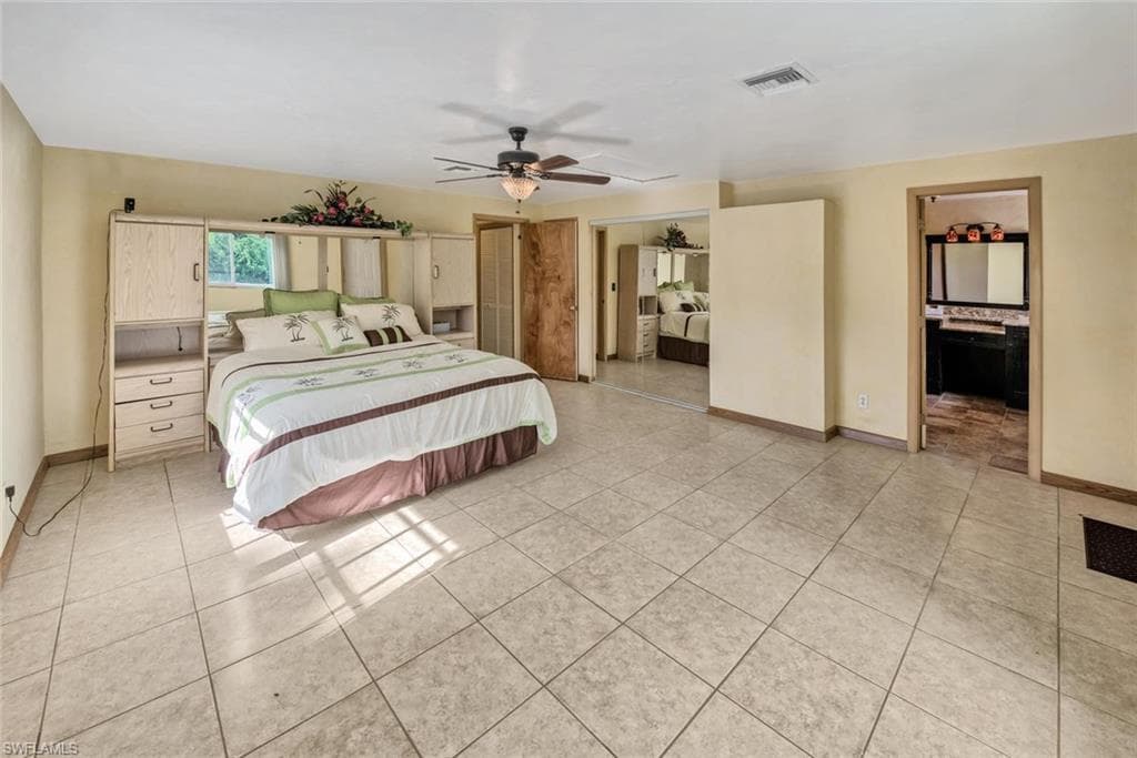 Bedroom with light tile patterned flooring and ceiling fan