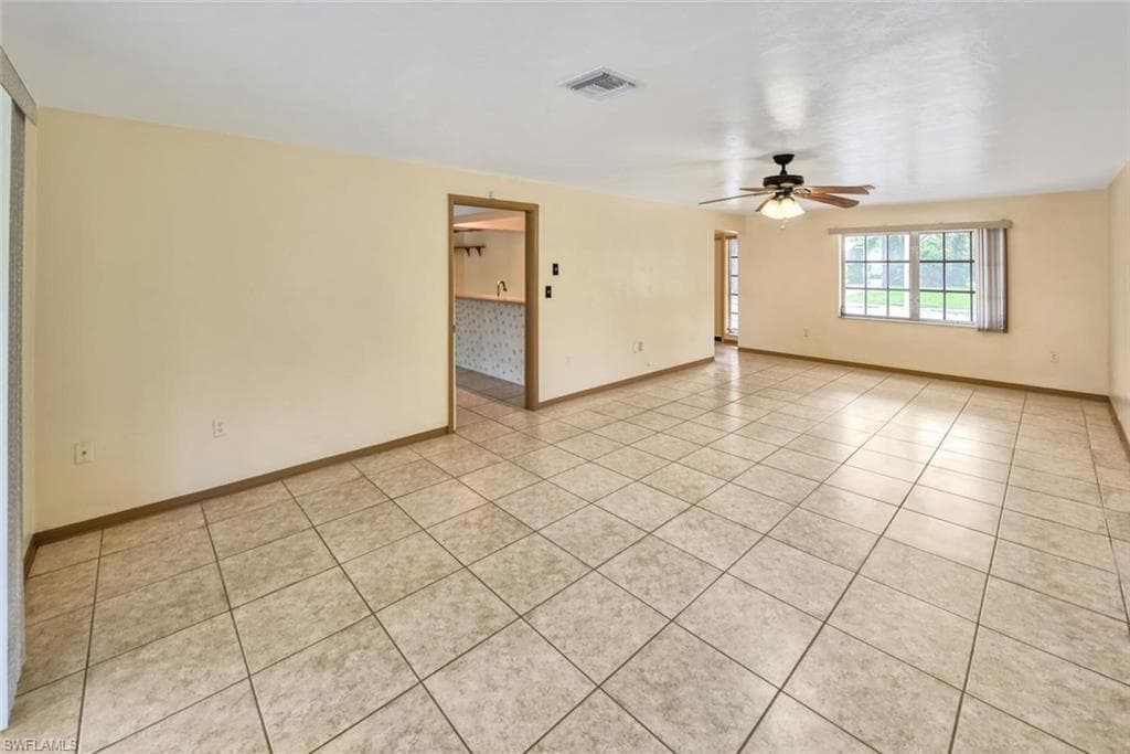 Unfurnished room with light tile patterned floors and ceiling fan