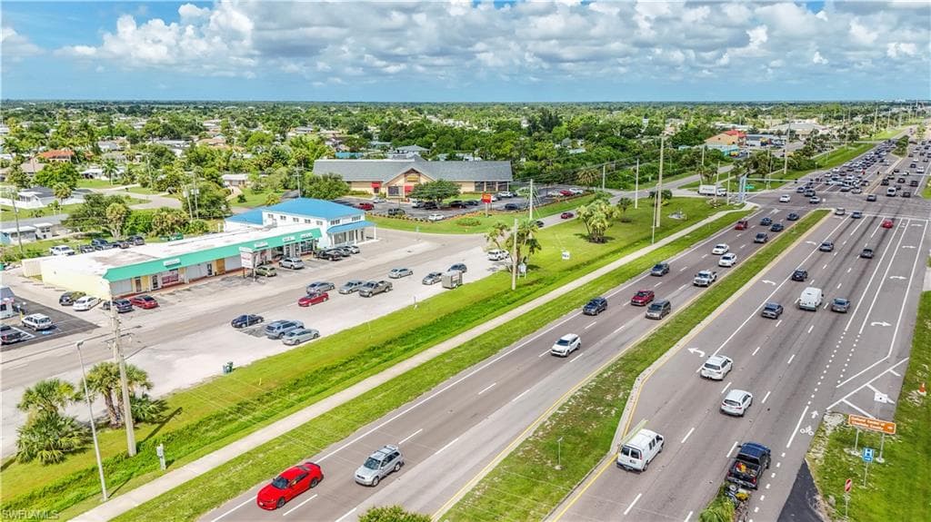 Commercial strip center featuring a blue metal roof and multiple storefronts