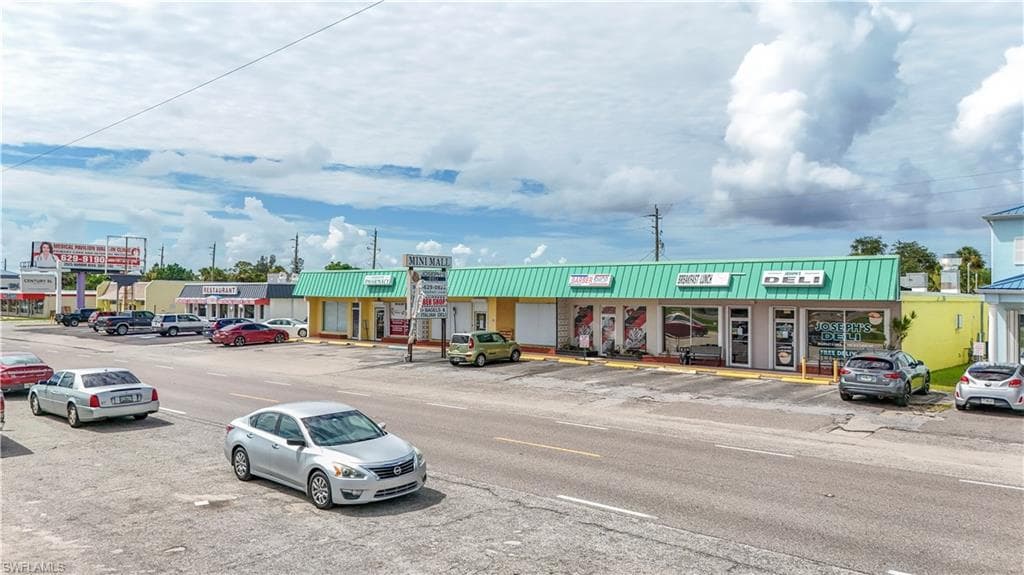 Commercial strip center featuring a green metal roofline and multiple storefronts