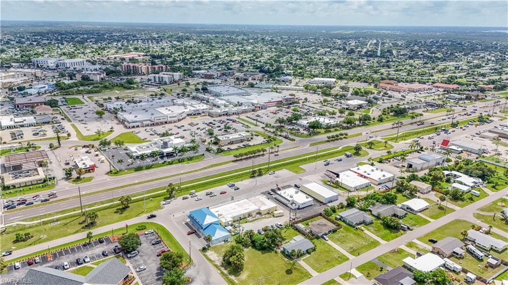 Aerial perspective showcasing a dense commercial corridor with multiple retail centers and extensive paved parking areas