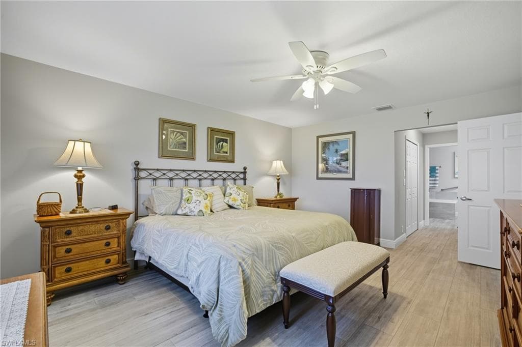 Bedroom featuring wood-finish flooring, a ceiling fan, and a light-toned wall color