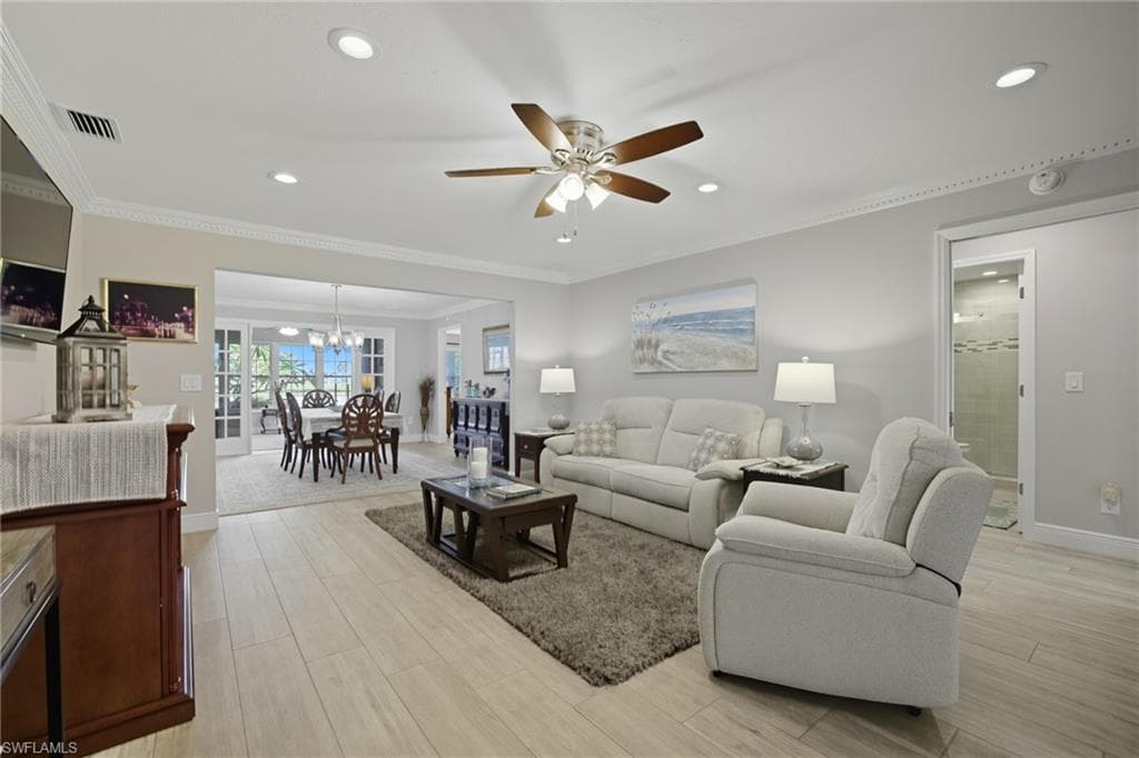 Living area featuring light wood-finish flooring, recessed lighting, and crown molding