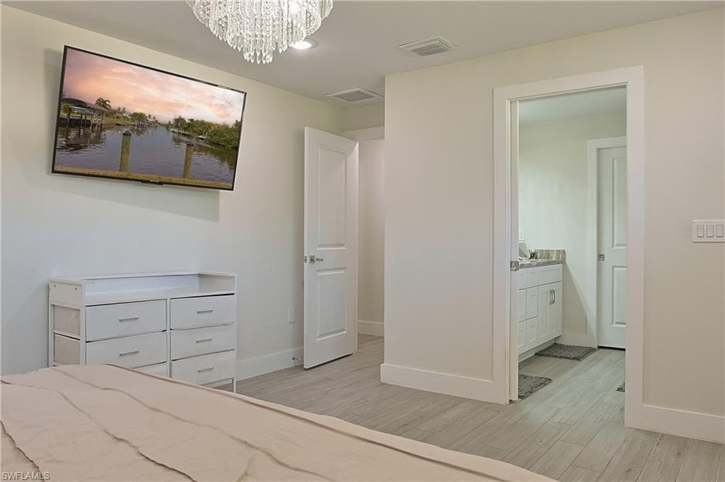 Recessed lighting, wood-finish flooring, and a crystal chandelier illuminate this space