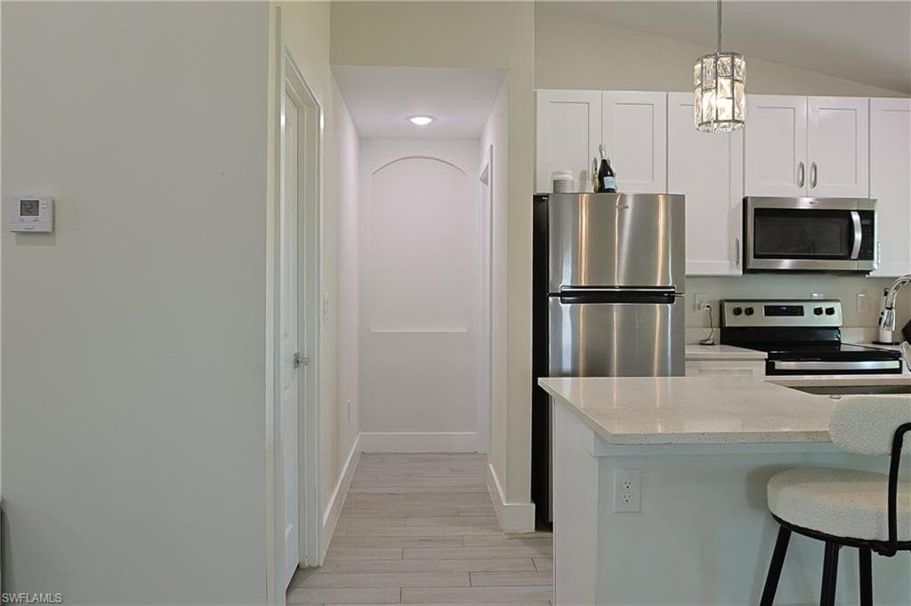 Kitchen featuring white shaker cabinetry, stainless steel appliances, and light-toned countertops