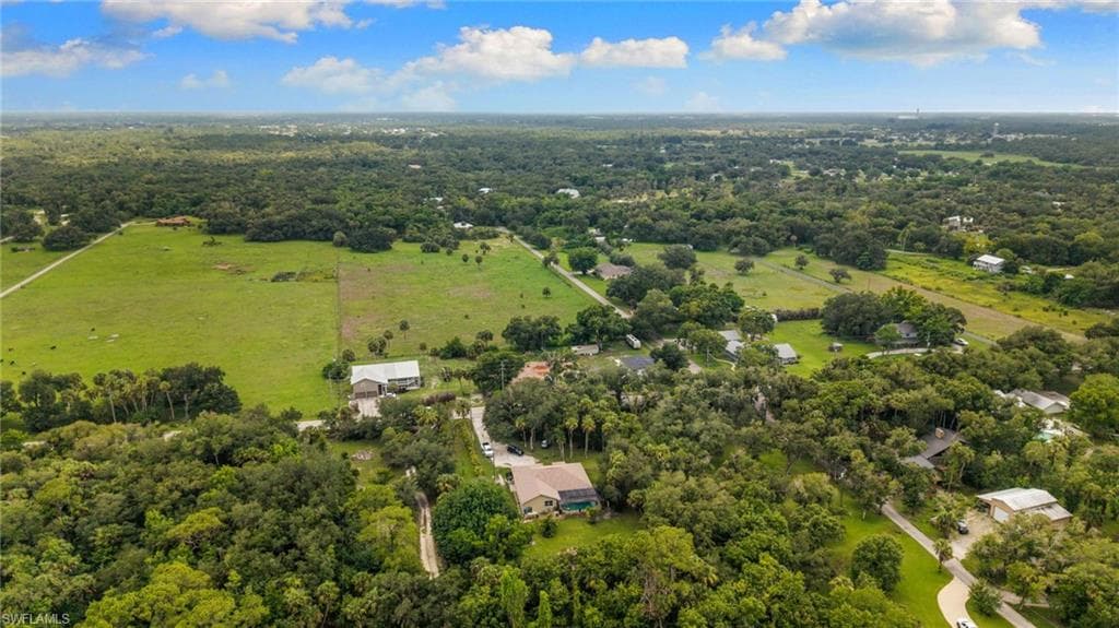 Expansive aerial perspective showcasing a verdant rural landscape with scattered residences and substantial green spaces
