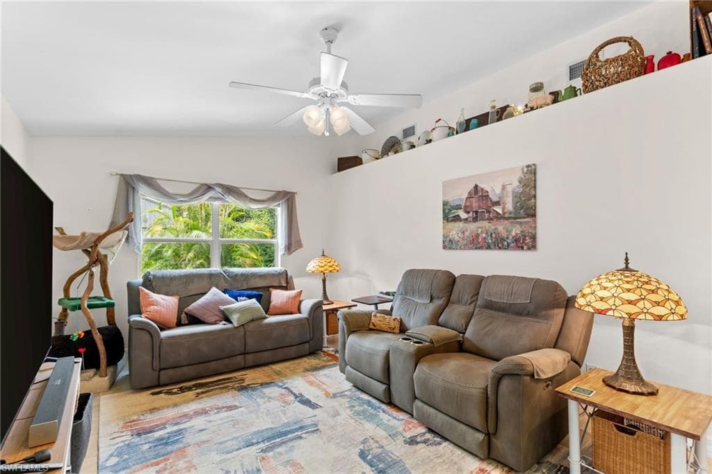 Living space featuring a white ceiling fan, high ledge for display, double-paned window, and light-colored walls