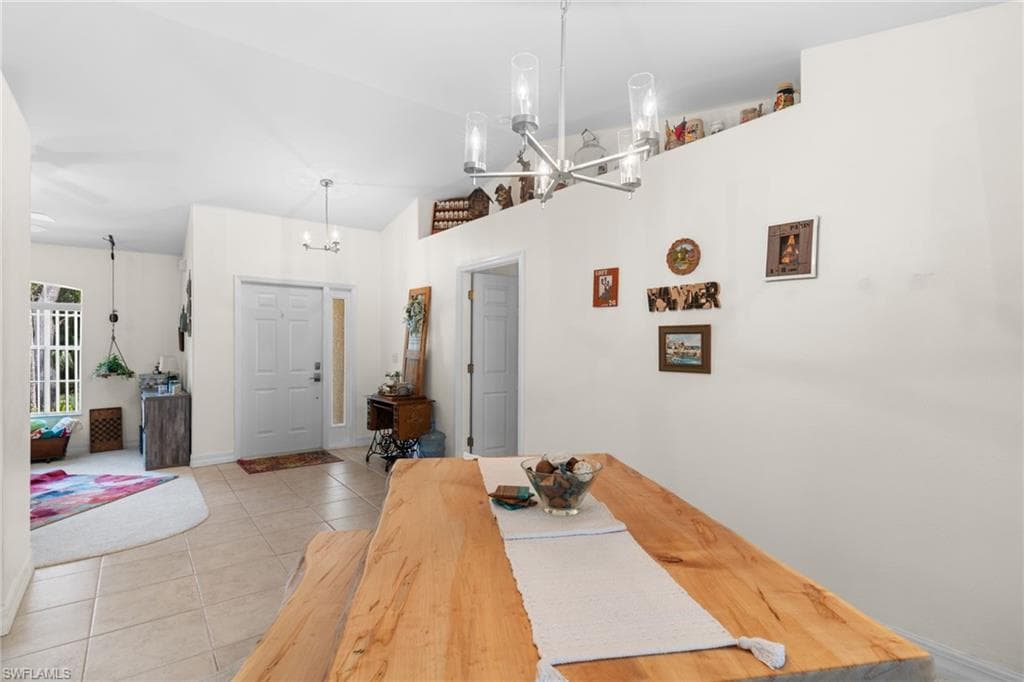 Open-concept dining area featuring a natural wood-finish dining table and a contemporary chandelier