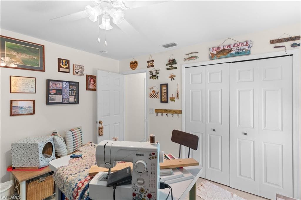 Room featuring a ceiling fan with light fixture, neutral wall color, and white bi-fold closet doors