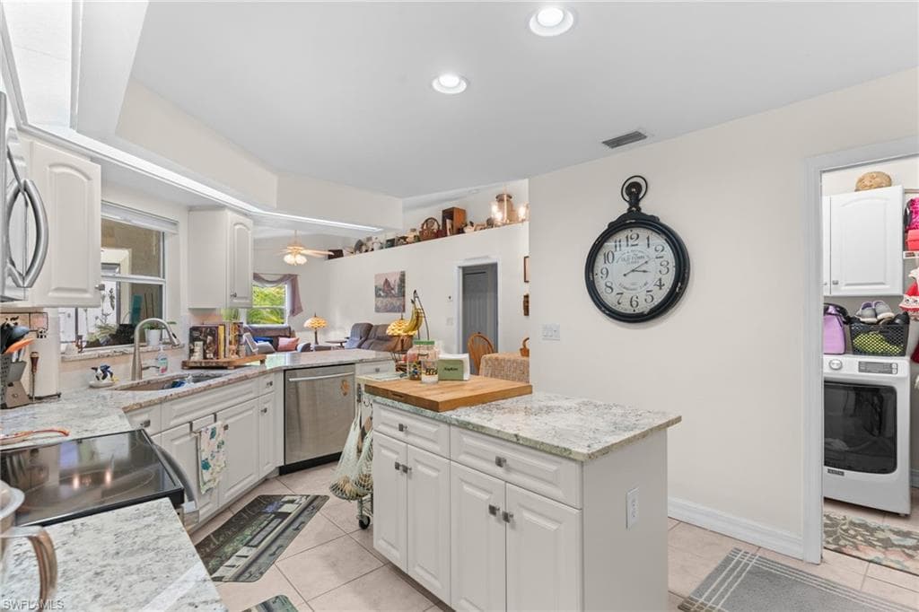 Kitchen featuring white cabinetry, light-toned countertops, and stainless steel appliances