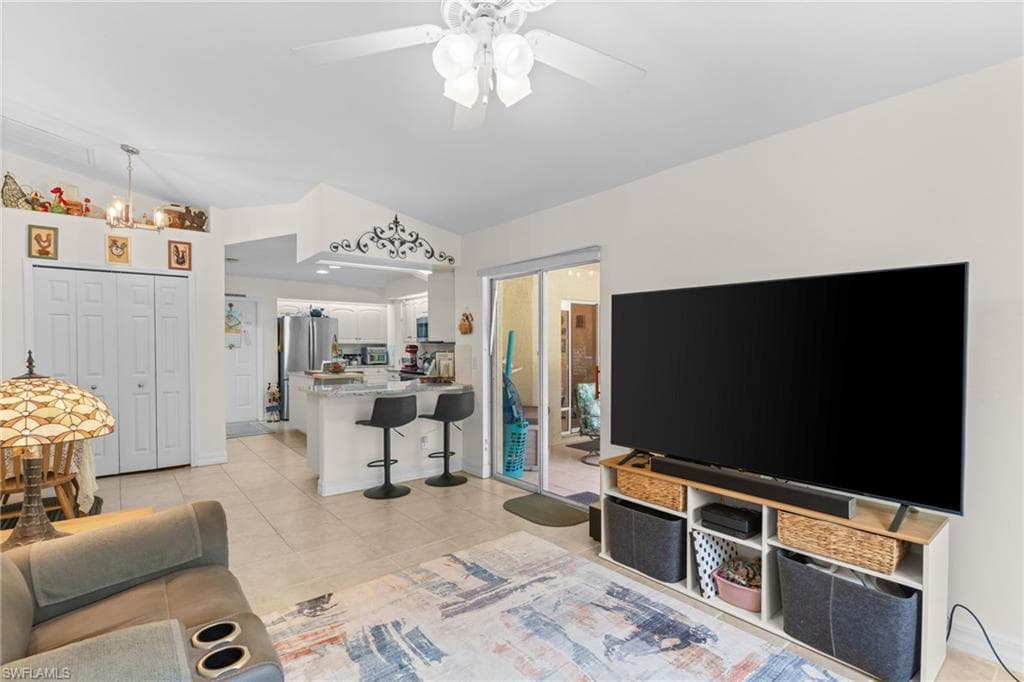 Open-concept living space featuring a kitchen with a breakfast bar, stainless steel appliances, and a pass-through to the living area