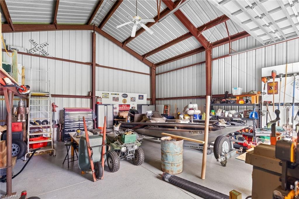 Spacious metal building featuring a vaulted ceiling with exposed brown metal beams, corrugated metal walls, and a light gray concrete floor
