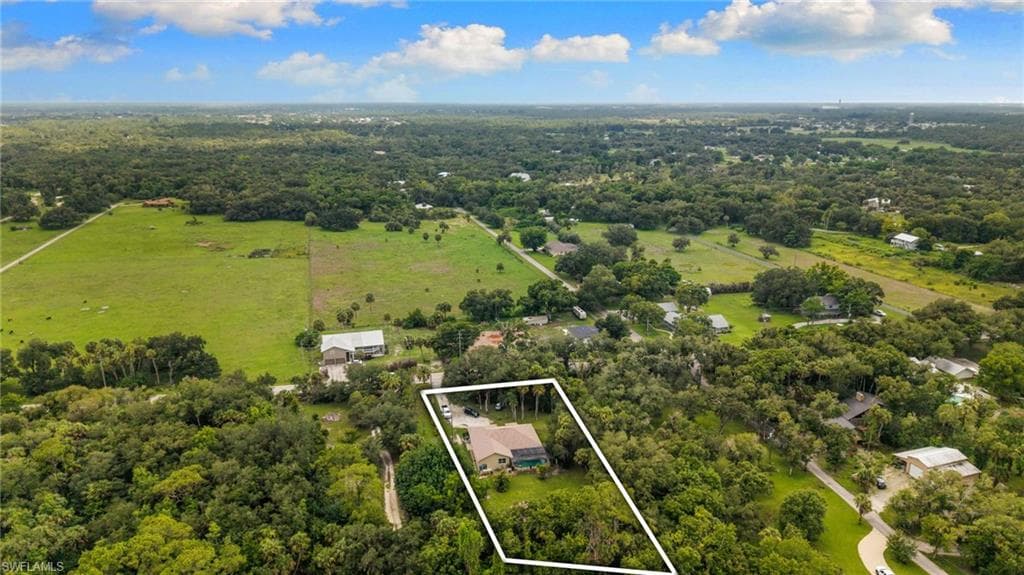 Aerial perspective showcasing a property surrounded by mature trees and natural landscaping