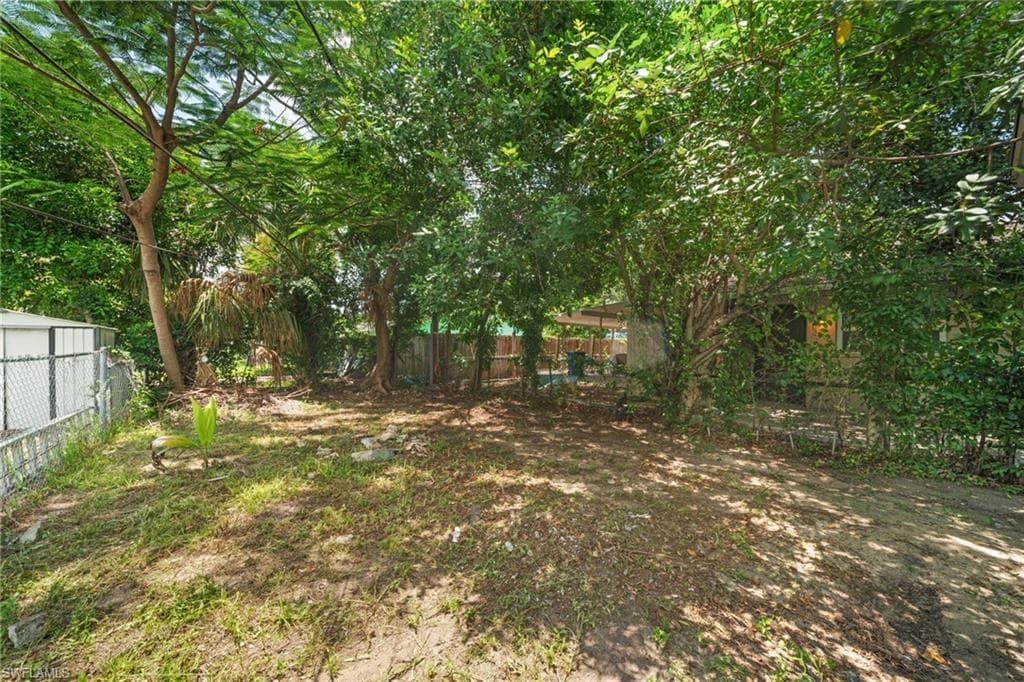 Expansive backyard featuring mature trees and established perimeter fencing
