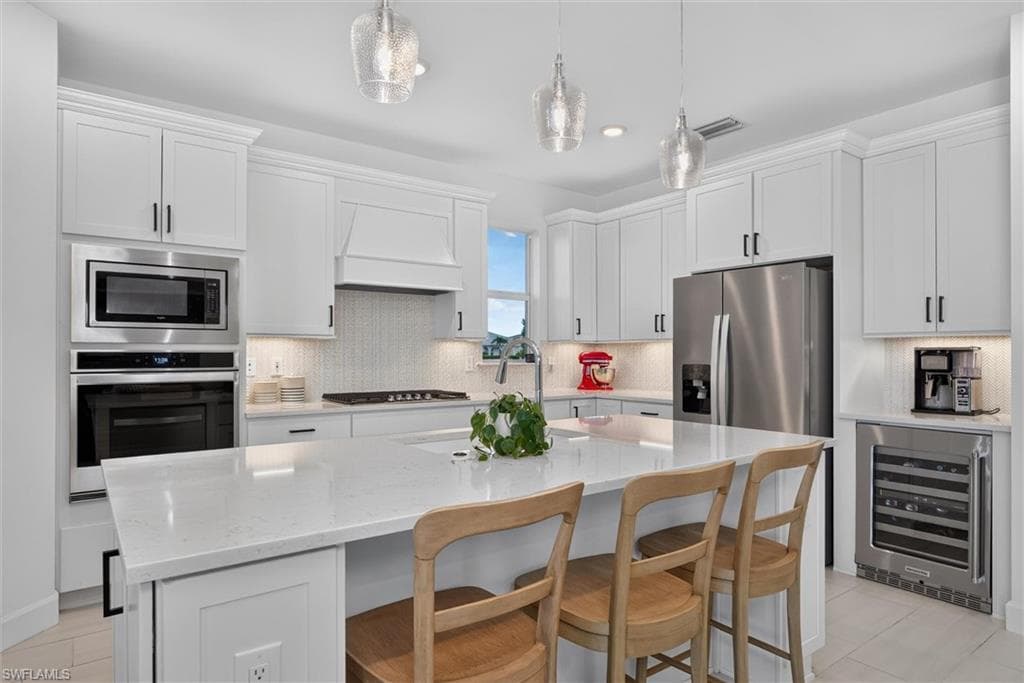 Kitchen with ample cabinet, don't miss the cabinets on the ends of the island for extra storage and notice the window to bring in extra lighting