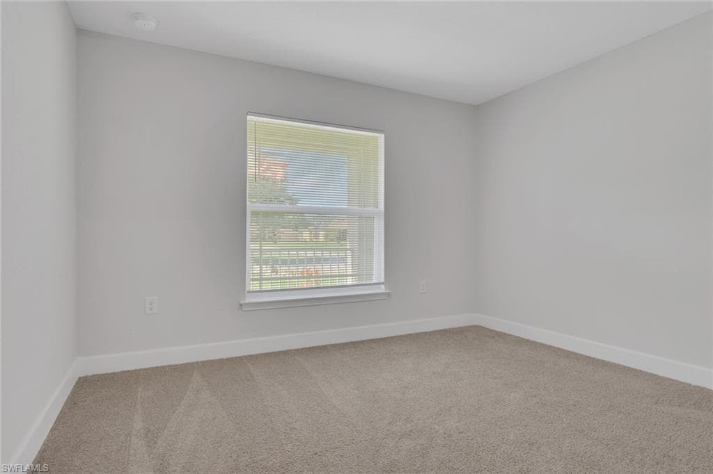 Carpeted room with a single window featuring horizontal blinds