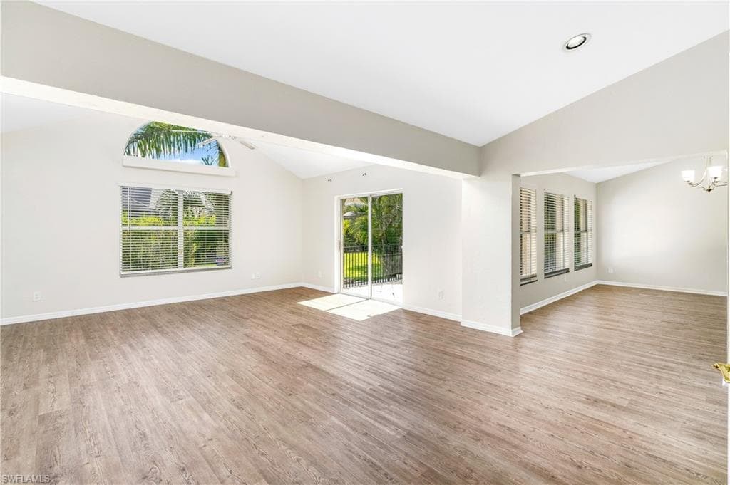 Spacious living room with soaring vaulted ceilings and abundant natural light,