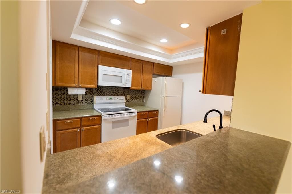 Modern kitchen with cabinets recessed ceiling lights and granite