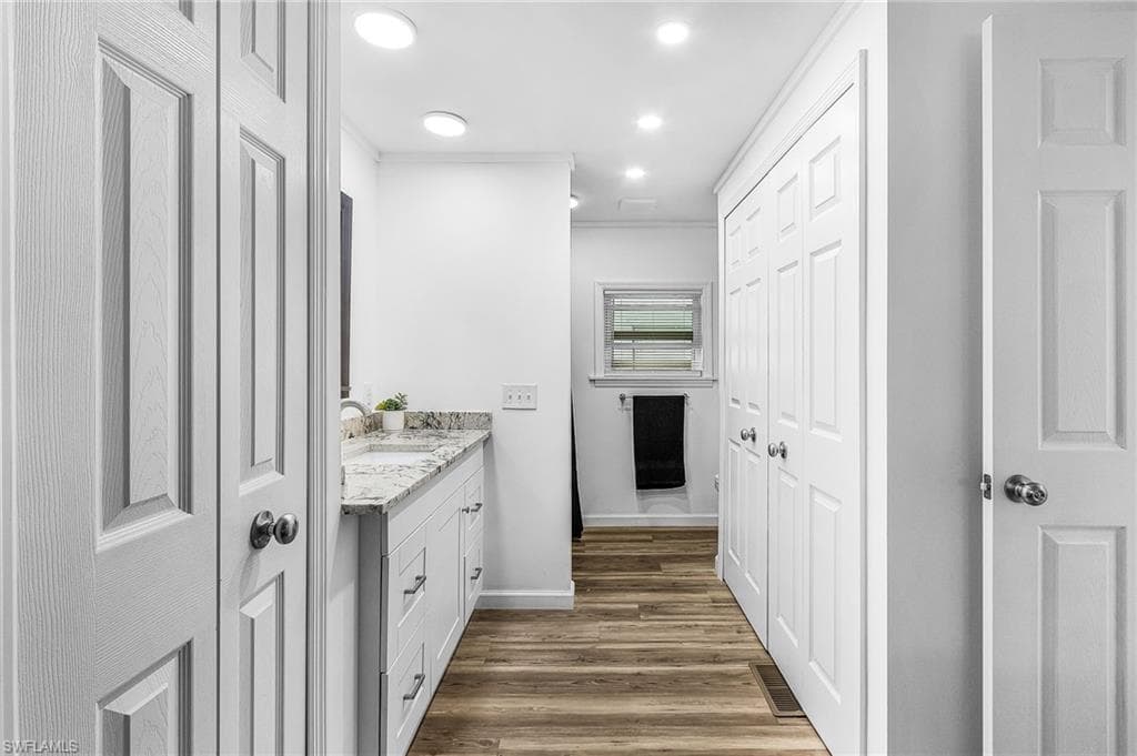 Bathroom vanity featuring a light-colored countertop, dual sinks, and white shaker-style cabinetry
