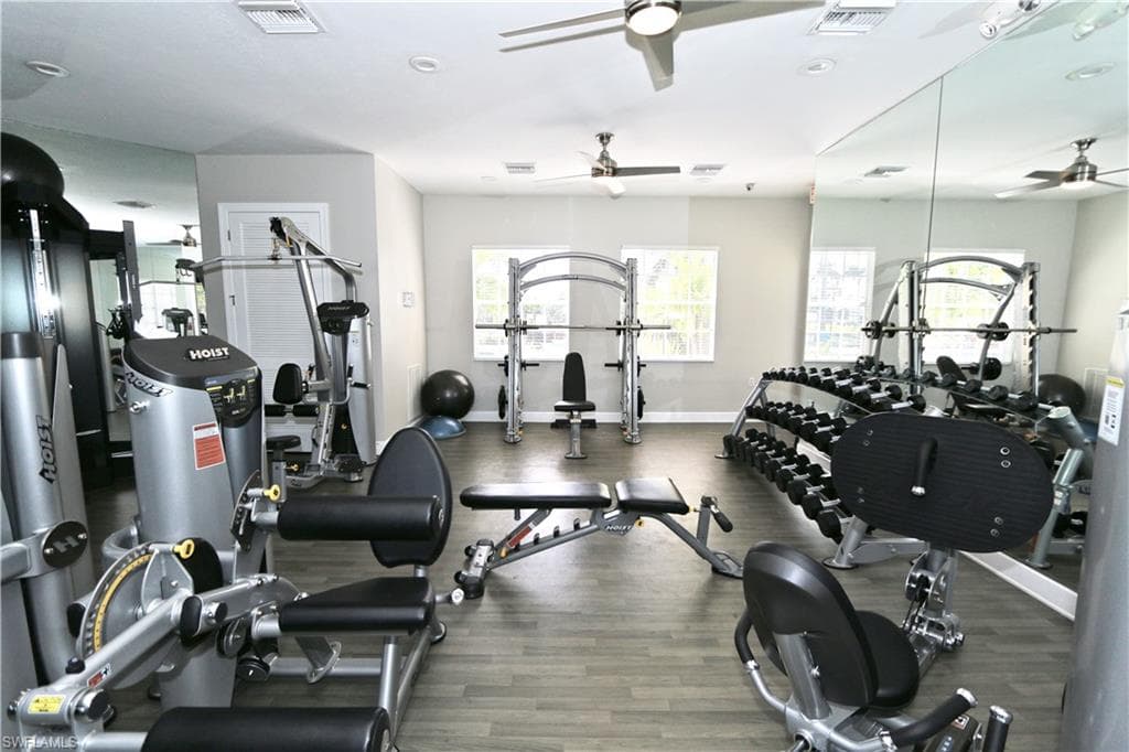 Fitness center featuring wood-finish flooring, recessed lighting, and mirrored walls