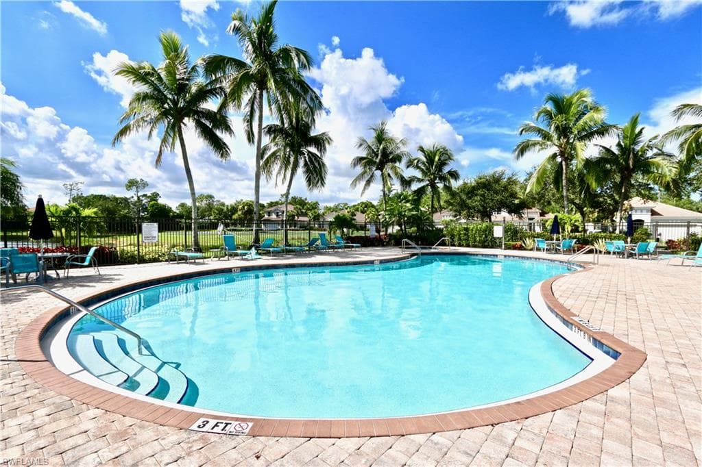 Resort-style swimming pool featuring a curved design and integrated steps