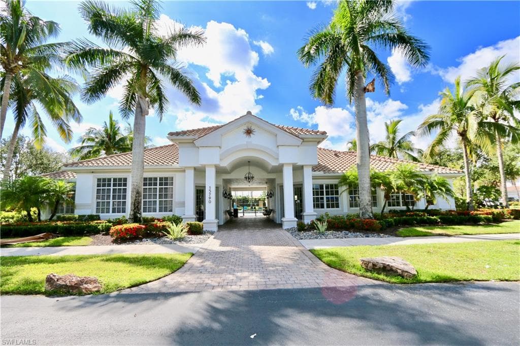 Stately entrance featuring a covered portico, arched entryway, and dual hanging light fixtures