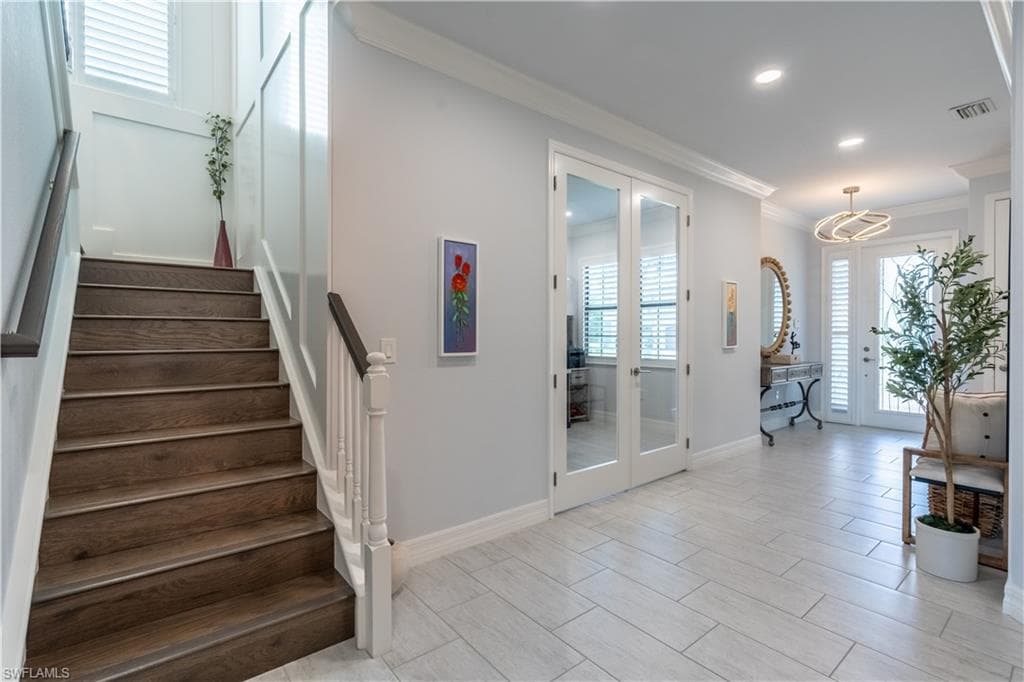 Exquisite glass french doors open to office next to the beautiful staircase