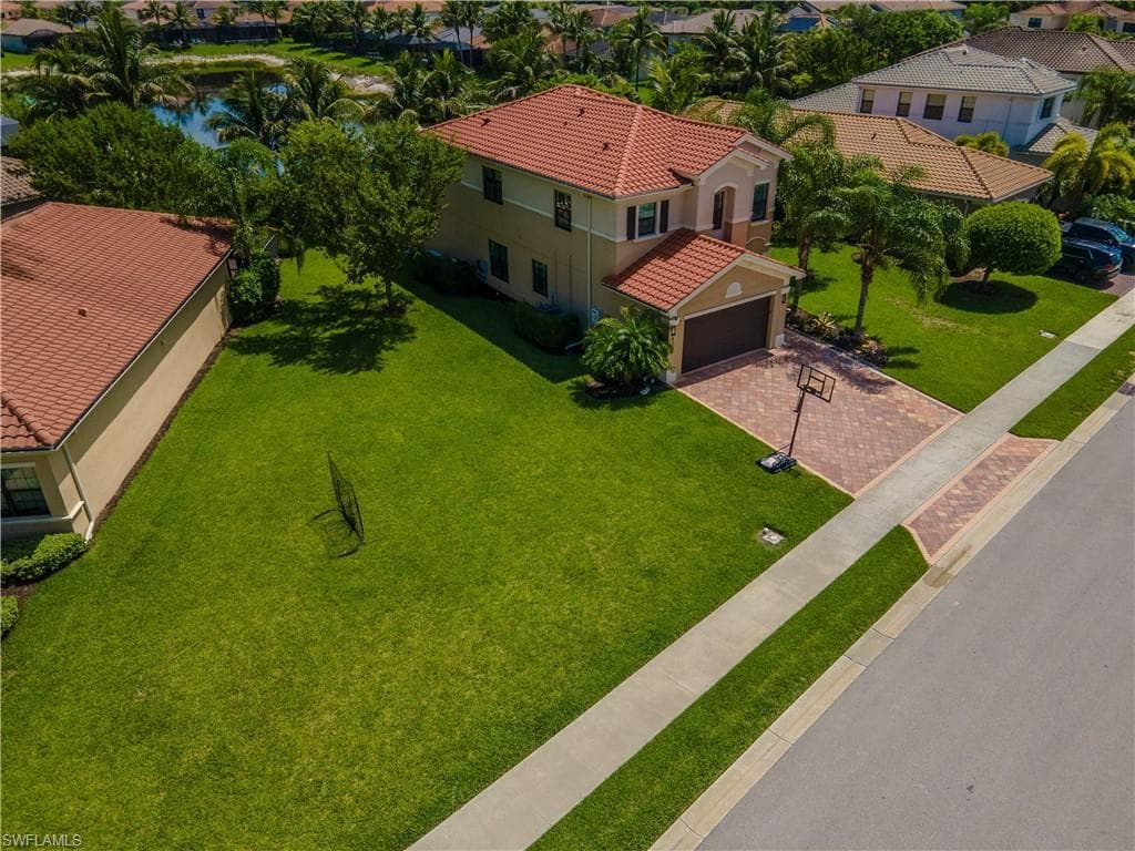 Two-story residence featuring a massive side yard, tiled roof and a light-toned exterior