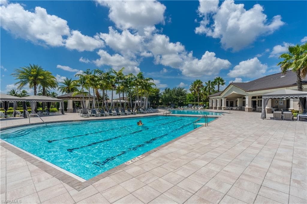 Expansive community swimming pool featuring dedicated lap lanes, an integrated shallow entry, and surrounding paved decking