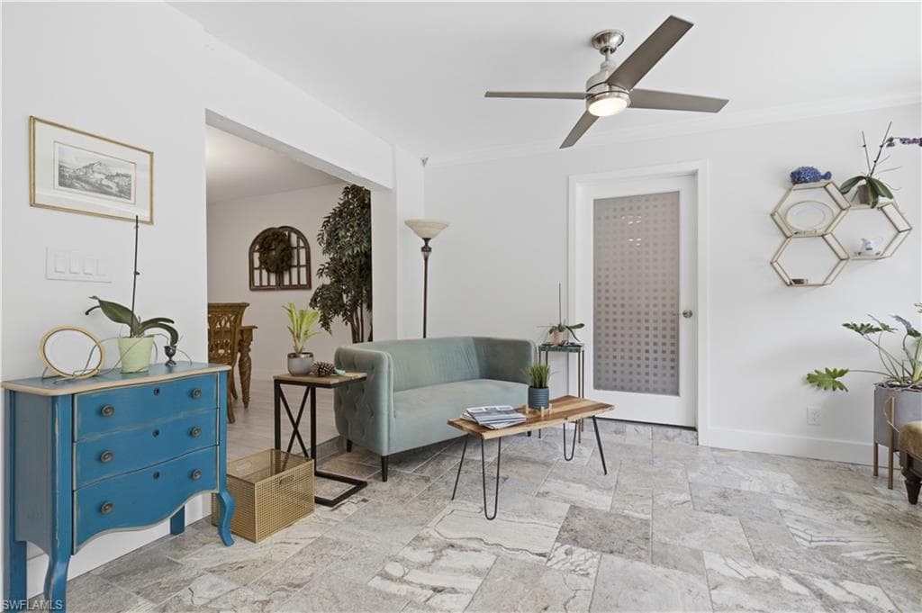 Spacious living area featuring light-toned tile flooring, recessed lighting, and a contemporary ceiling fan